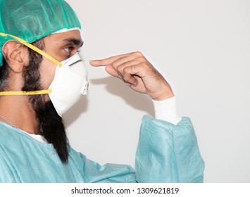 Portrait Of Doctor With Mustache Wearing Hat And Mask N 95,Handsome Bearded Man Is Black Hair And Dark Brown Eyes Wear White Doctor Uniform And Focus Finger To Mask And Copy Space,Sikh Man,medical Man