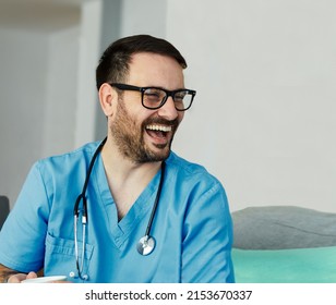 Portrait Of A Doctor Or Nurse Caregiver With Senior Man Laughing And Having Fun At Home Or Nursing Home