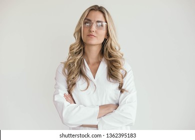 Portrait of a doctor, nurse or scientist. Studio shot of a blonde woman in her 20s wearing a white lab coat.