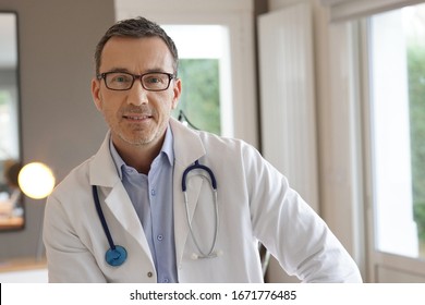 Porträt eines Arztes, der im Büro steht, Kamera ansieht