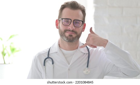 Portrait Of Doctor Showing Call Me Sign