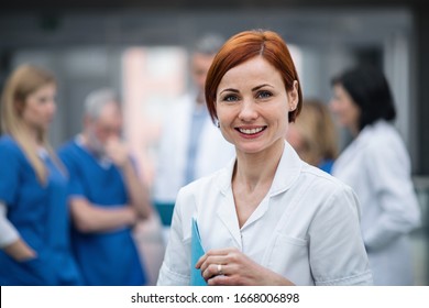 Portrait Of Doctor Standing In Hospital On Medical Conference.