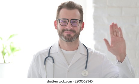 Portrait Of Doctor Waving Hand For Hello, Welcoming