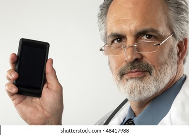 Portrait Of A Doctor Wearing Glasses And A White Lab Coat.  He Is Holding Up A Cell Phone And Looking At The Camera. Horizontal Shot.