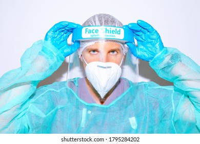 Portrait of doctor wearing protection suit to prevent coronavirus. Healthcare professional adjusting face shield - Powered by Shutterstock