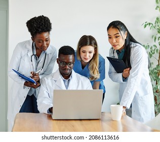 portrait of a doctors and nurses with laptop sitting by desk on their office