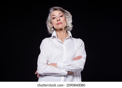 Portrait Of A Domineering, Arrogant Mature Woman Looking Down And Standing With Her Arms Crossed Isolated On A Black Background