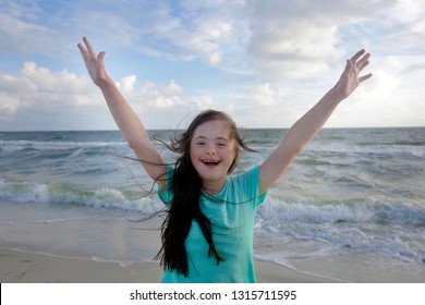 Portrait Of Down Syndrome Girl Smiling On Background Of The Sea