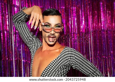 portrait of drag queen diva with fuchsia glitter background