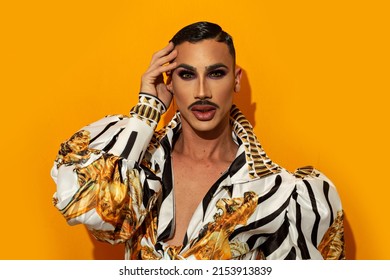 Portrait of drag queen with fashionable mustache yellow background