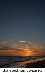 Portrait of dramatic sunset sky with clouds and reflection on the sea.