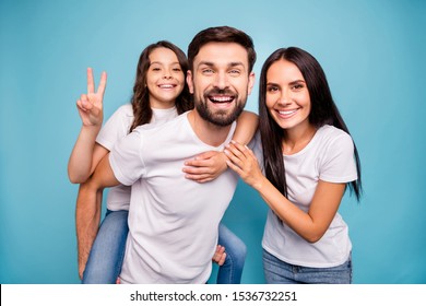 Portrait of dream dreamy positive bearded three people mommy daddy carry piggyback schoolkid make v-signs enjoy rest relax wear white t-shirt denim jeans isolated over blue color background