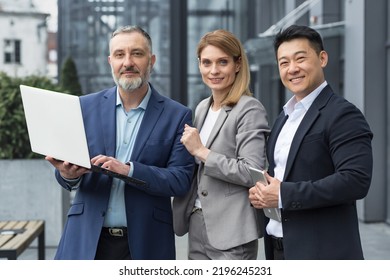 Portrait dream team IT specialists professionals team leaders outside office building looking at camera holding laptop discussing successful application project, specialists business suits smiling. - Powered by Shutterstock