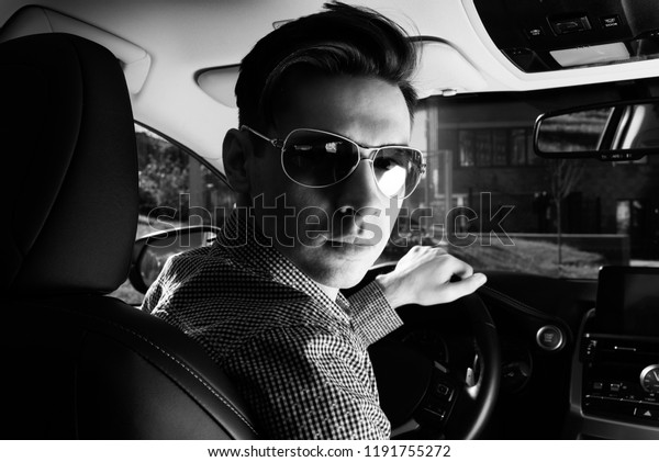 Portrait of driver in his car. looking camera,\
black and white photo