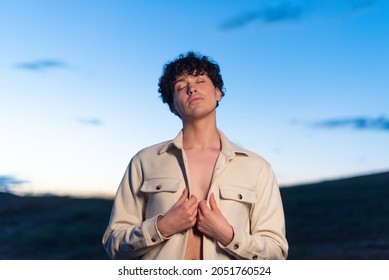 Portrait during dusk of a non binary male posing relaxed - Powered by Shutterstock