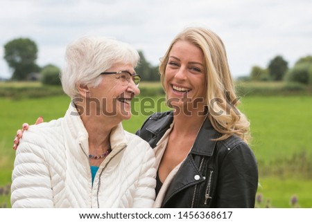 Portrait of a dutch grandmother and granddaughter in an outdoors setting.