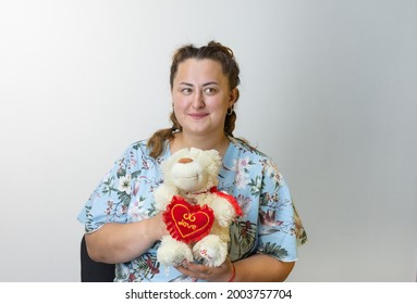 Portrait Of An Eastern European Young Gorgeous Woman With A Teddy Bear On A Light Background.