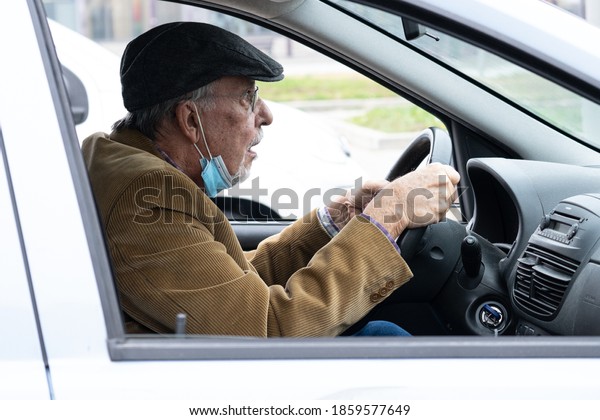 Portrait of an elder car driver wearing medical\
mask to prevent coronavirus\
infection