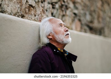 Portrait Of An Elderly Asian Man In The City Looking Up, Thoughtful.