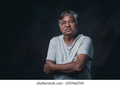 Portrait Elderly Asian Man With Crossed Arms On Black Background In The Studio.