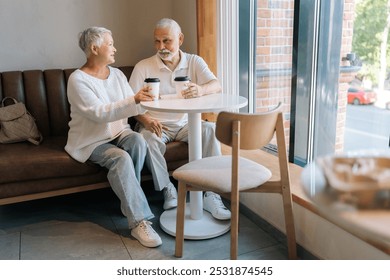 Portrait of elderly couple enjoying coffee in cozy cafe, chatting happily in sunlit room, radiating love and contentment. Happy retirement life filled with leisure, togetherness and cherished moments. - Powered by Shutterstock