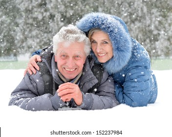 Portrait Of Elderly Couple Having Fun Outdoors In Winter Forest