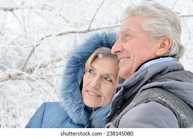 Portrait Of Elderly Couple Having Fun Outdoors In Winter Forest