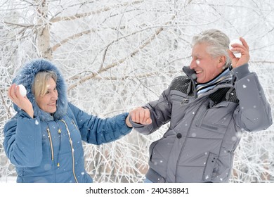 Portrait Of Elderly Couple Having Fun Outdoors In Winter Forest