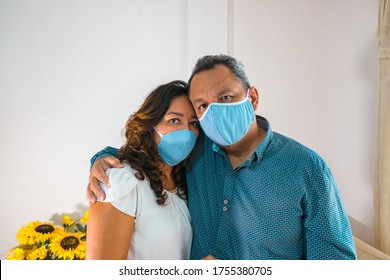 Portrait Of An Elderly Couple With Medical Mask In Their Living Room