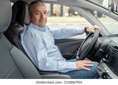 Portrait Of An Elderly Driver In Car Or Taxi