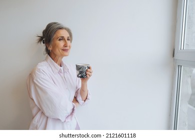 Portrait of elderly female in casual casual wear holding a mug