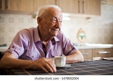 Portrait of an elderly gentleman having a morning coffee in the kitchen, looking far away in distance with uncertain look in his eyes, in nursing home or care house, life and health insurance concept  - Powered by Shutterstock