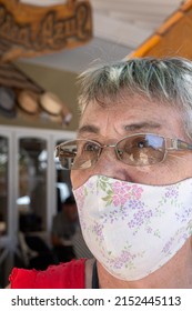 A Portrait Of An Elderly Hispanic Woman With Glasses Wearing Fabric Reusable Face Mask Outdoors On A Sunny Day