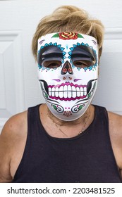 Portrait Of An Elderly Lady With A Catrina Mask Celebrating Halloween And All Souls' Day, On A White Background. Celebration, Costume, Party And Mask Concept.