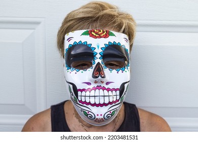 Portrait Of An Elderly Lady With A Catrina Mask Celebrating Halloween And All Souls' Day, On A White Background. Celebration, Costume, Party And Mask Concept.