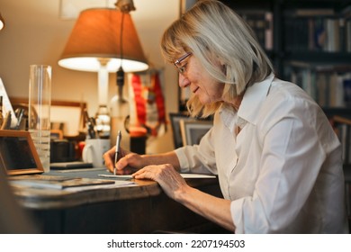 portrait of an elderly lady while she writes - Shutterstock ID 2207194503