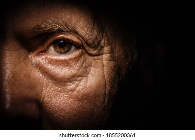 Portrait of an elderly man with brown eyes on a black background view from close up. - Shutterstock ID 1855200361