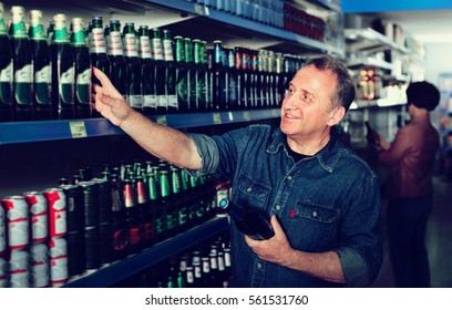 Portrait Of An Elderly Man Buying A Beer At The Grocery Store