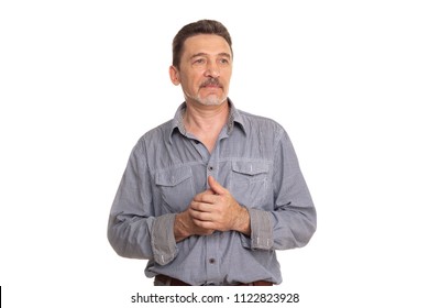 portrait of an elderly man with a gray beard stands in a gray shirt and looks thoughtfully aside. portrait  old man lost  thought. senior adult. isolated on white backgrounda.