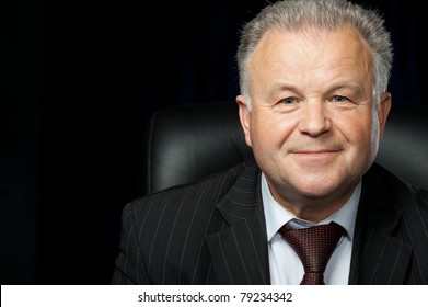 Portrait Of The Elderly Man. A Photo Against A Dark Background