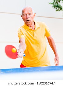 portrait of elderly man with rackets for table tennis