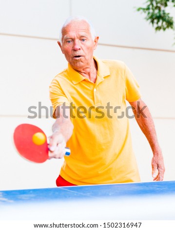 portrait of elderly man with rackets for table tennis