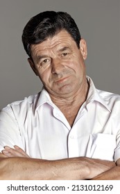 Portrait Of An Elderly Man In A Studio On A Gray Background