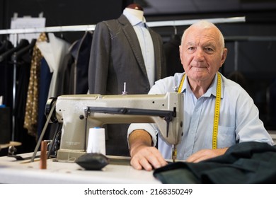 Portrait Of Elderly Man Tailor Working On Sewing Machine At Studio