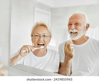 Portrait of an elderly senior couple cleaning brushing their teeth in front of mirror in bathroom. Dental hygiene, vitality, love and beauty concepts - Powered by Shutterstock