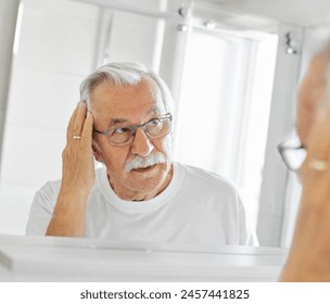 Portrait of an elderly senior man grooming and combing his hair in front of  mirror in bathroom - Powered by Shutterstock