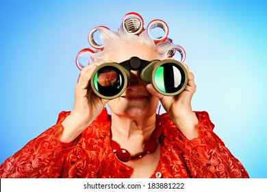 Portrait Of An Elderly Woman In Curlers Looking Ahead Through Binoculars.