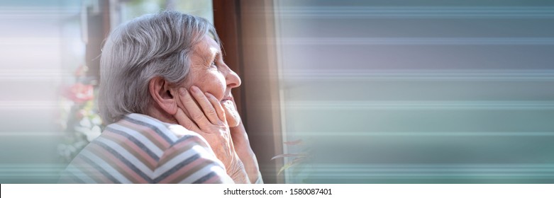 Portrait of elderly woman looking out the window and dreaming; panoramic banner