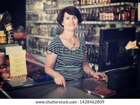 Portrait of an elderly woman near the cashdesk at the grocery store