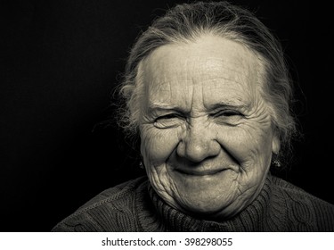 Portrait Of Elderly Woman On Dark Background. Toned.